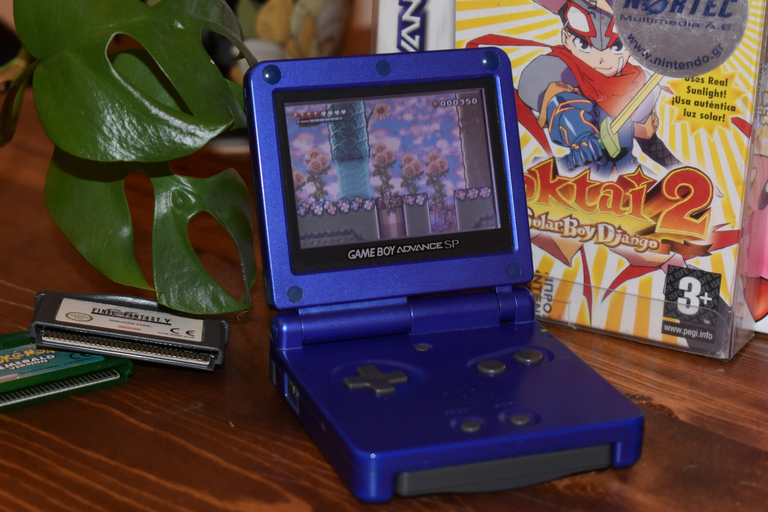 A GBA SP running Wario Land with an assortment of games next to it